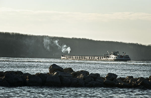 Motorgüterschiff fährt bei niedrigem Wasserstand auf der Donau zu Berg.
