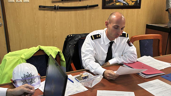 Beamter der Wasserschutzpolizei kontrolliert die Schiffstagebücher. © Pospiech