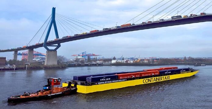 Ein Container Taxi unter der mit LKW überfüllten Köhlbrandbrücke